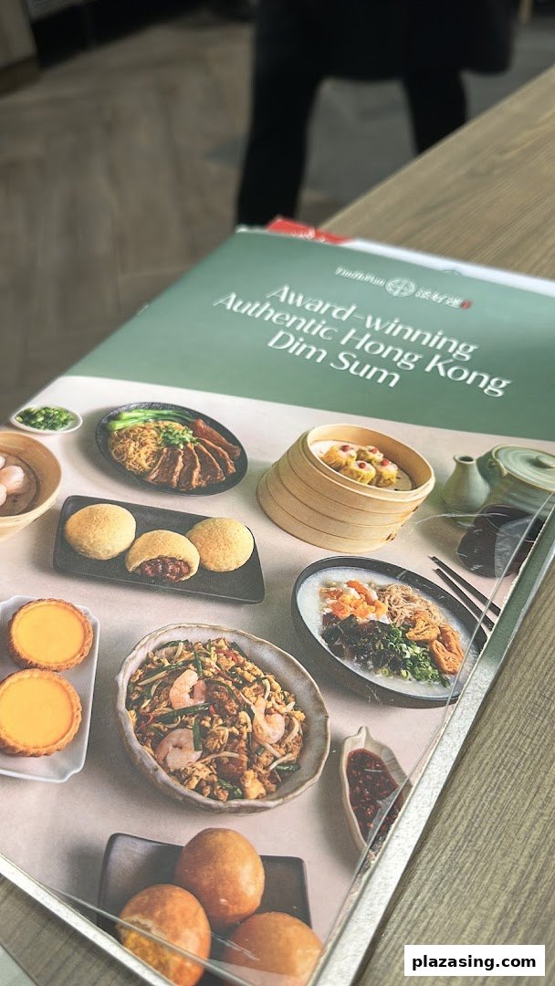 A close-up view of the Tim Ho Wan menu cover, showcasing various authentic Hong Kong dim sum dishes.