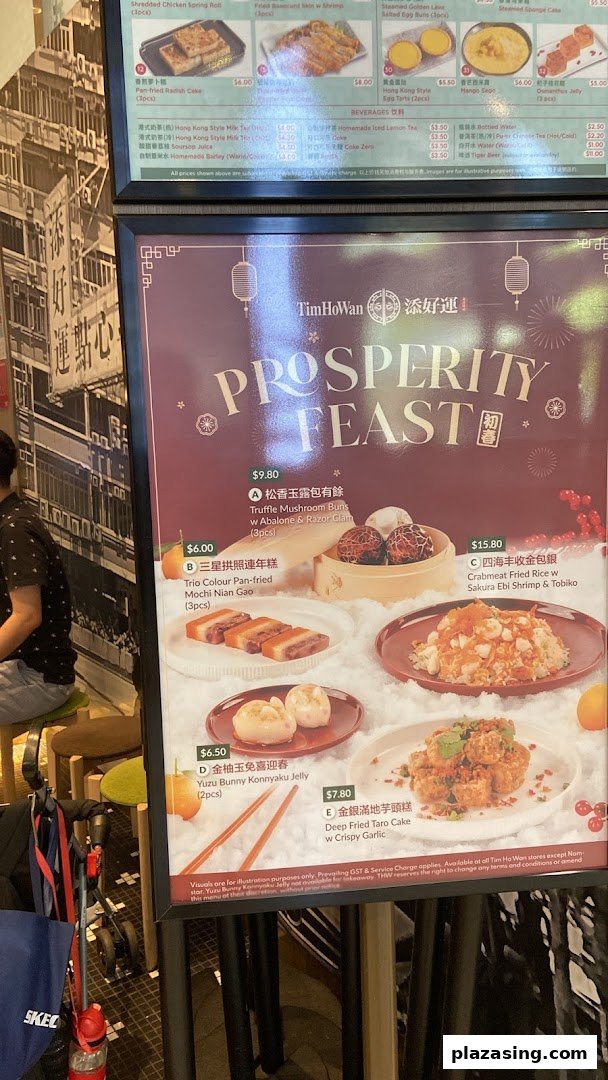 Tim Ho Wan's 'Prosperity Feast' promotional menu board with various dim sum and beverages.