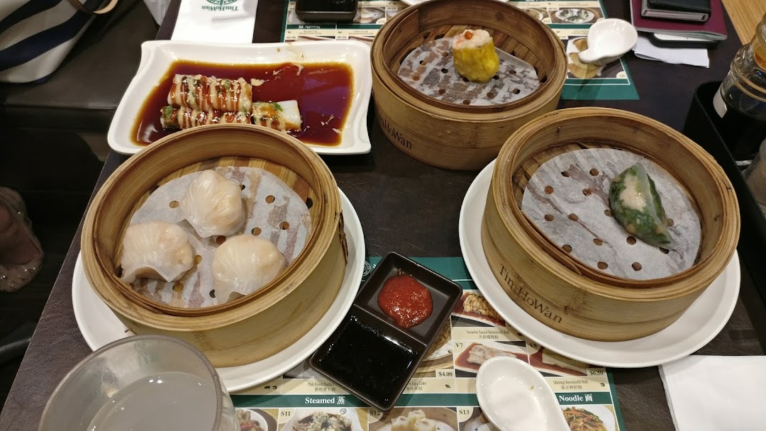 A table filled with various delicious dim sum dishes, including dumplings and siu mai, from Tim Ho Wan.