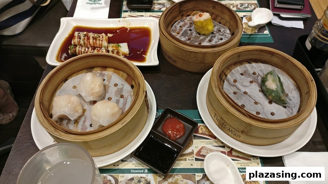 A table filled with various delicious dim sum dishes, including dumplings and siu mai, from Tim Ho Wan.