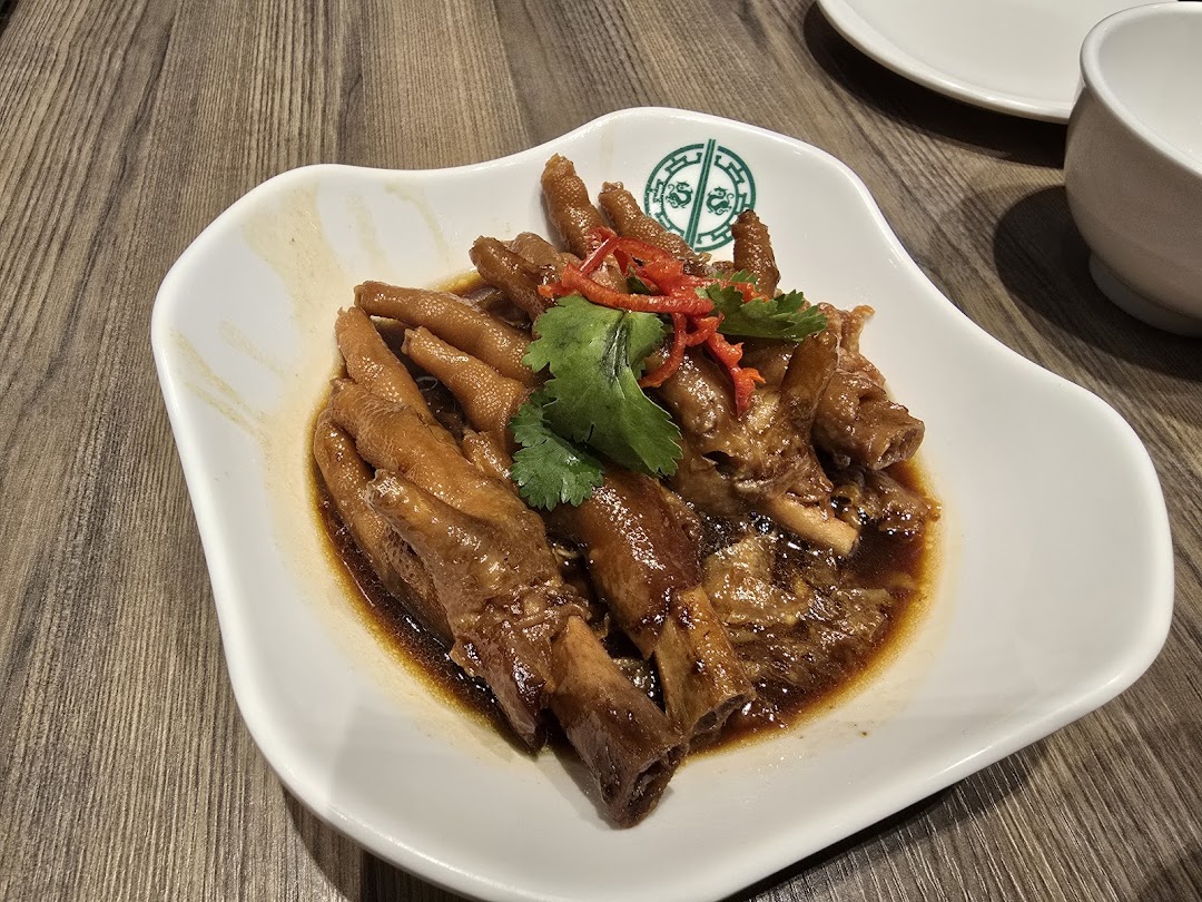 A plate of braised chicken feet in a rich sauce, garnished with chili and cilantro, from Tim Ho Wan.