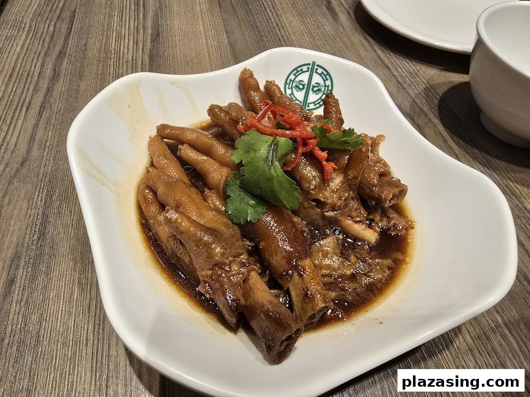 A plate of braised chicken feet in a rich sauce, garnished with chili and cilantro, from Tim Ho Wan.