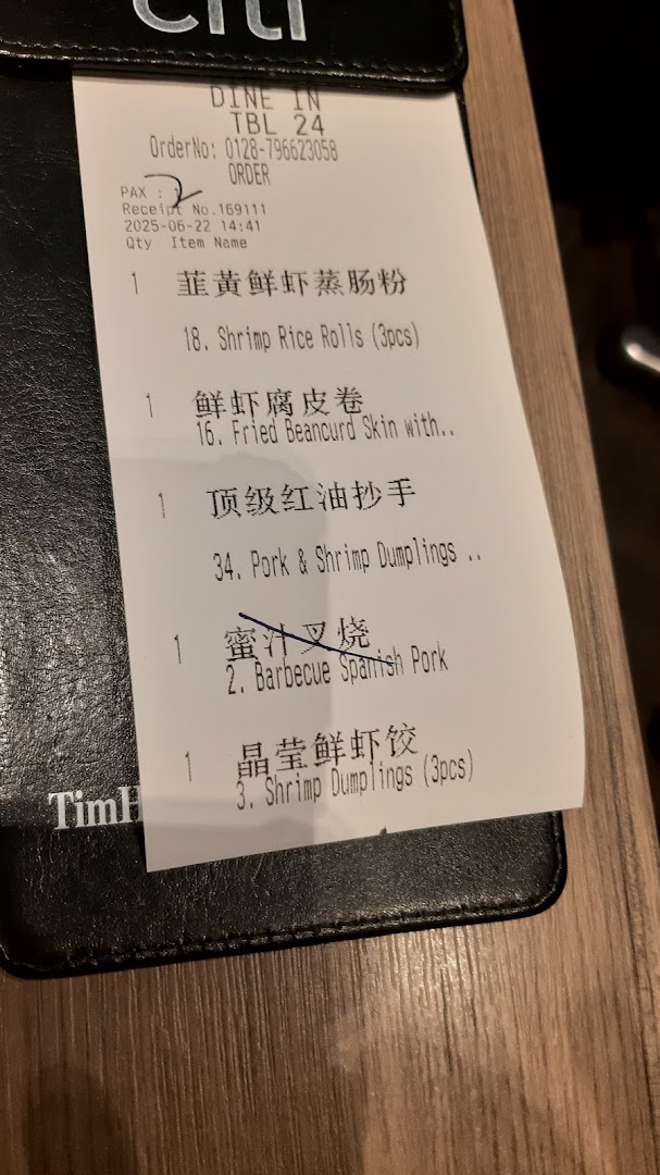 A close-up of a Tim Ho Wan order slip showing various dim sum items and order details.