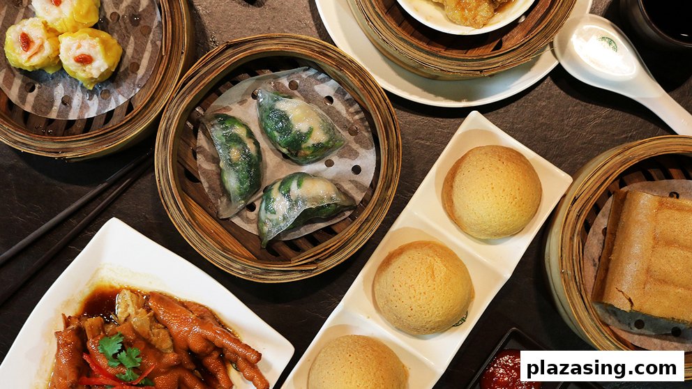 A top-down view of various delicious dim sum dishes, including dumplings, buns, and chicken feet.