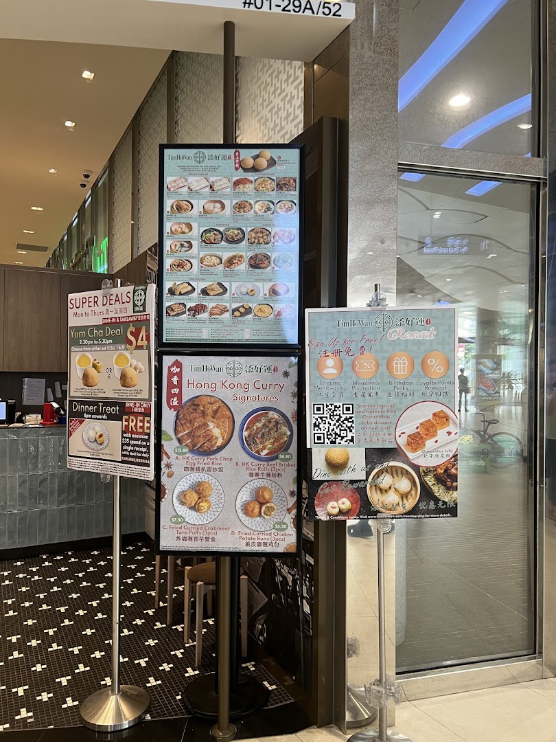 Tim Ho Wan's shop entrance featuring multiple display stands with menus, special deals, and membership information.