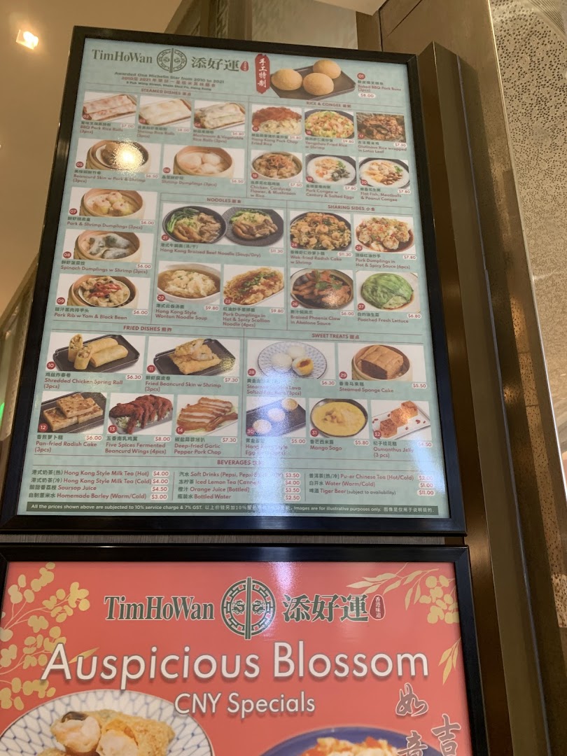 A detailed menu board for Tim Ho Wan, showcasing a variety of dim sum, noodles, rice, and beverages.