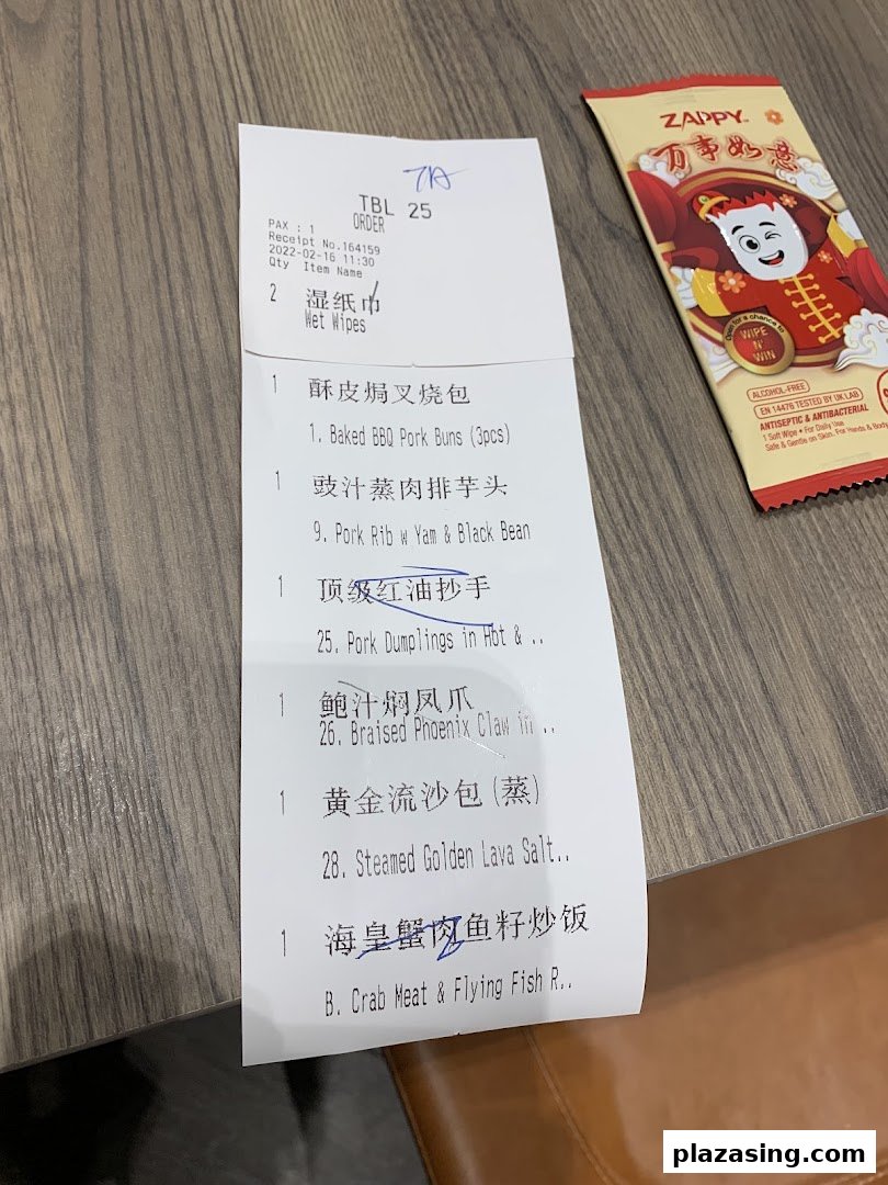 A close-up of a Tim Ho Wan order receipt listing various dim sum items and a wet wipe packet.