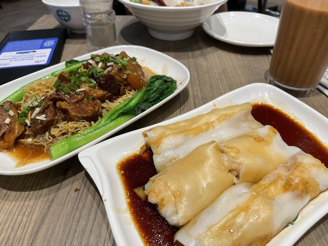 Delicious Tim Ho Wan dishes: braised beef noodles, rice rolls, and a refreshing drink on a table.