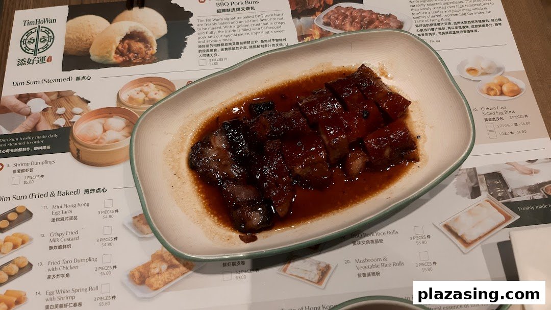 A plate of char siu and a Tim Ho Wan menu displaying various dim sum items and prices.