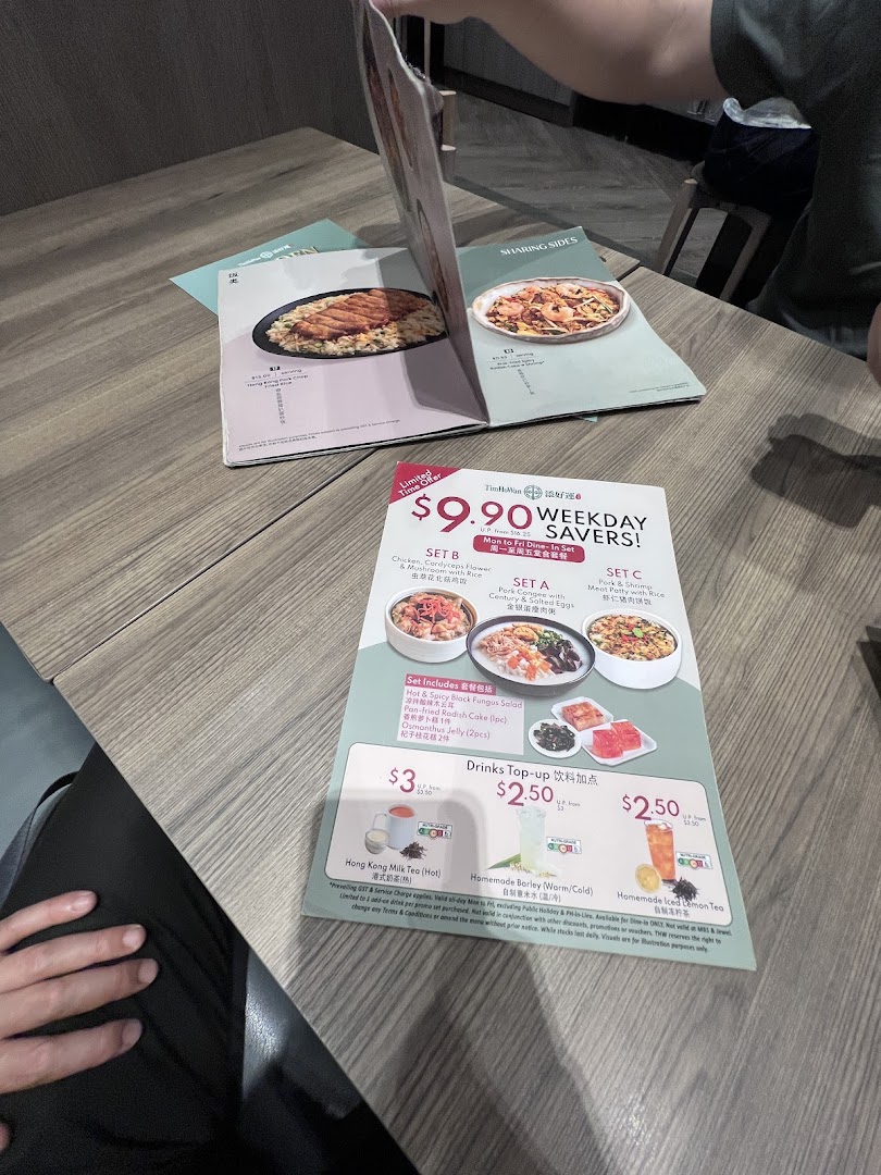 A table with Tim Ho Wan menus, featuring a 'Weekday Savers' special offer and drink top-ups.