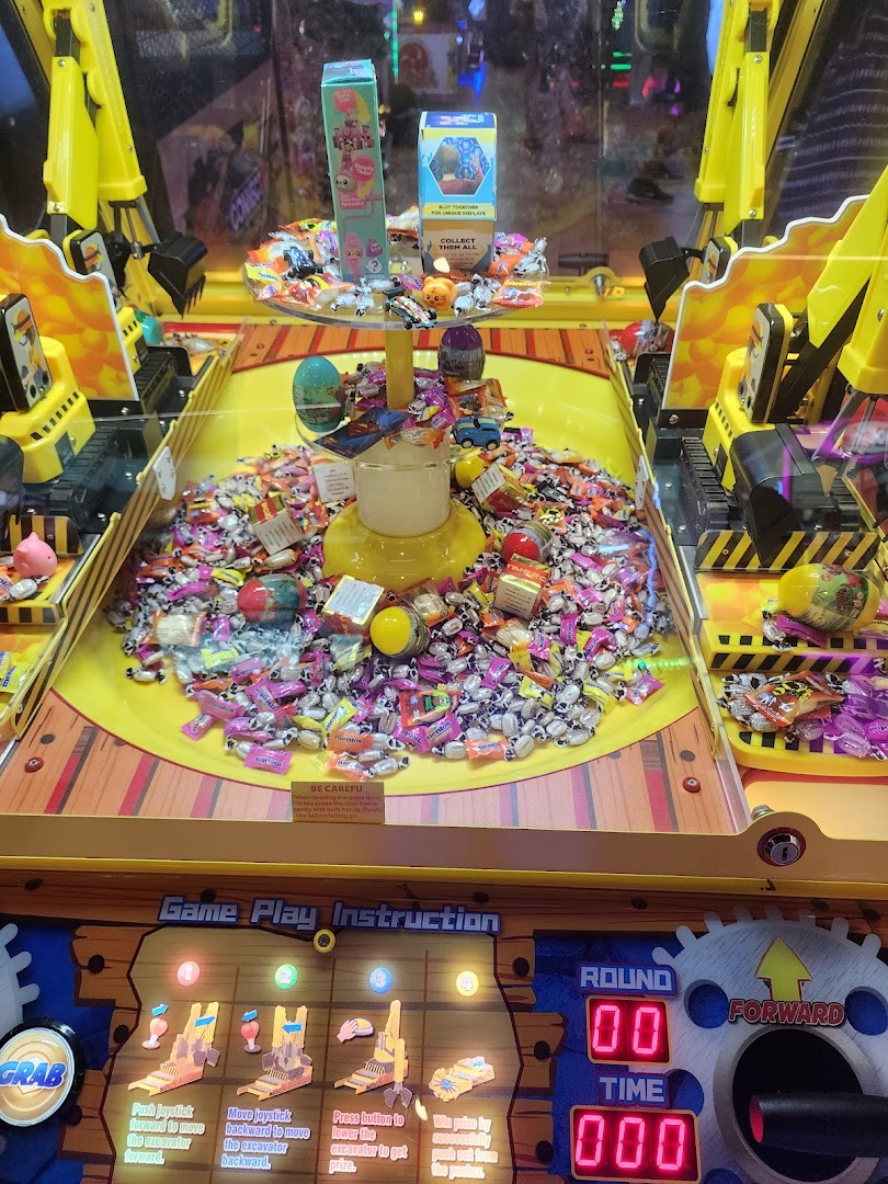 A vibrant arcade game filled with candies and prizes, showing game instructions and controls.