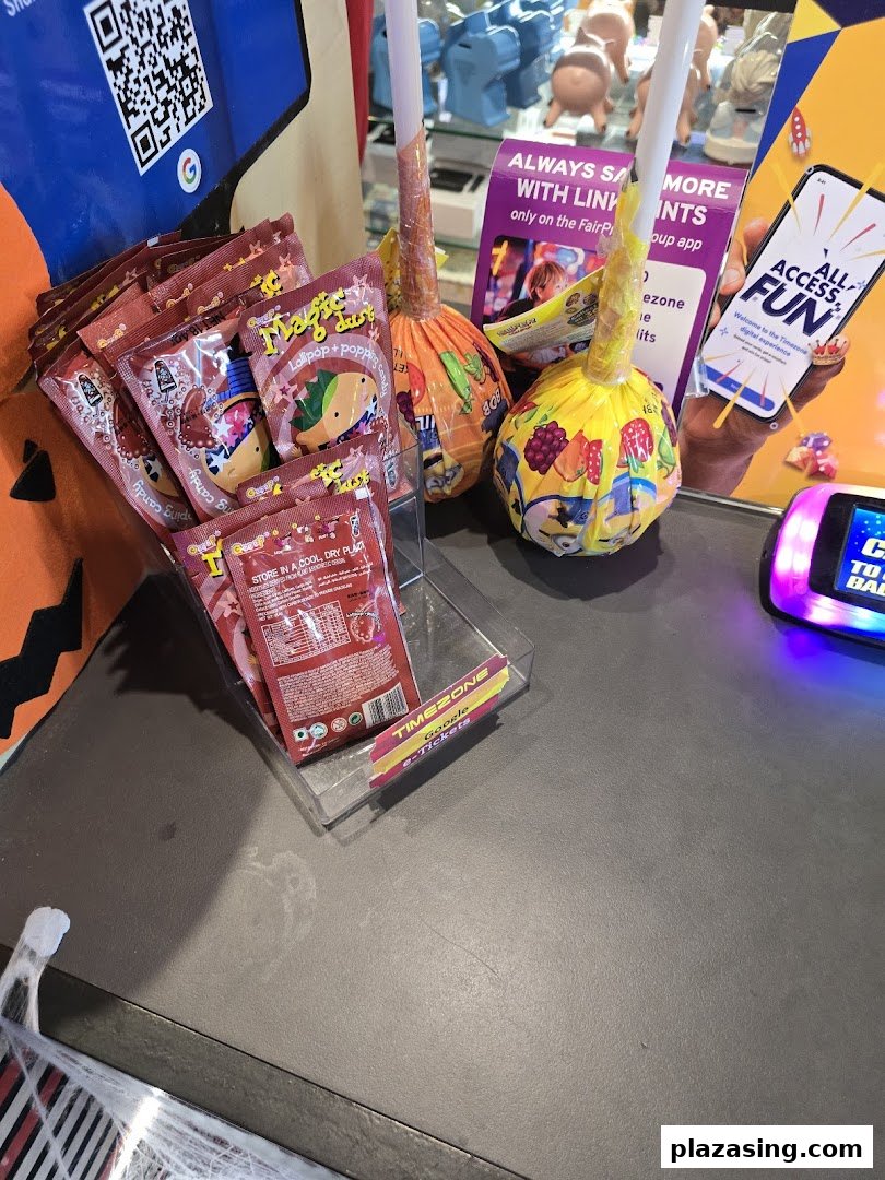 A counter display at Timezone featuring candies, lollipops, and promotional materials for their digital experience and e-tickets.