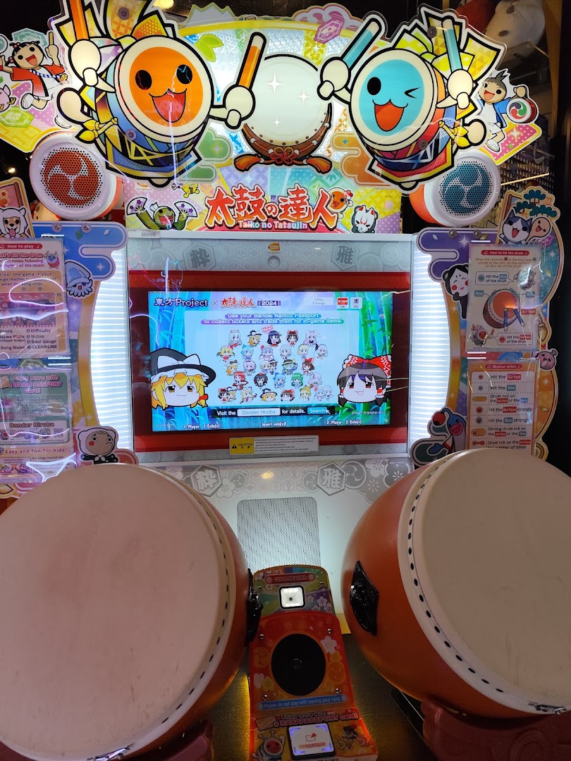 A vibrant Taiko no Tatsujin arcade game machine with two large drum controllers.