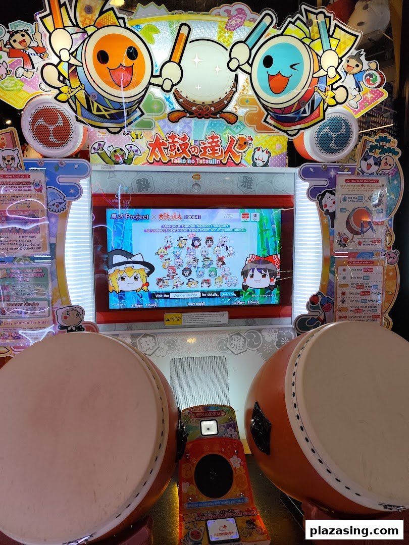 A vibrant Taiko no Tatsujin arcade game machine with two large drum controllers.