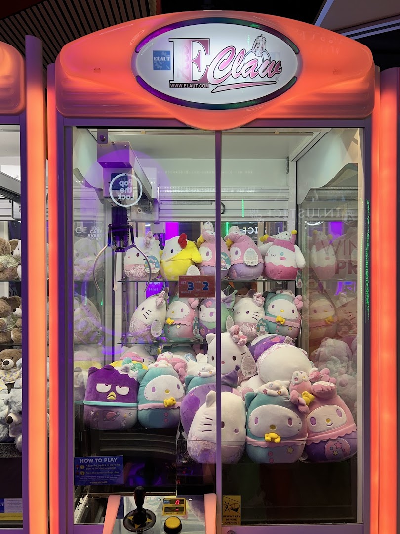 A brightly lit claw machine filled with various colorful plush toys, ready to be won.