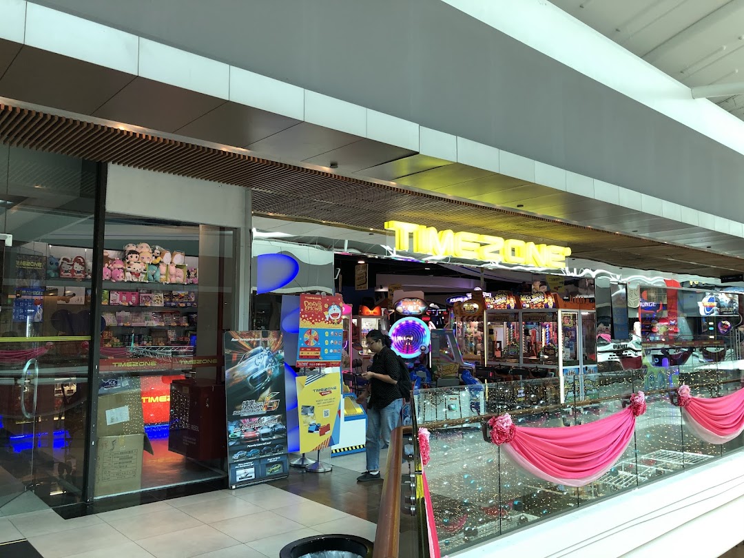 View of Timezone arcade entrance, showcasing various games, a prize counter, and a customer.