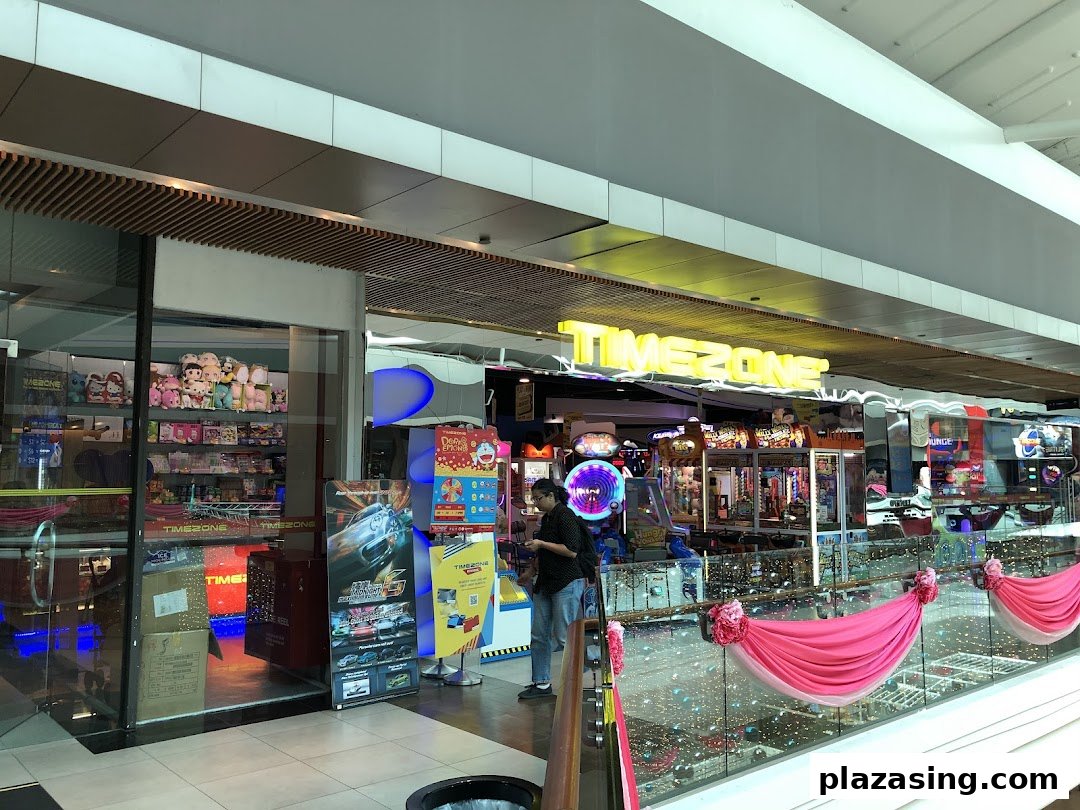 View of Timezone arcade entrance, showcasing various games, a prize counter, and a customer.