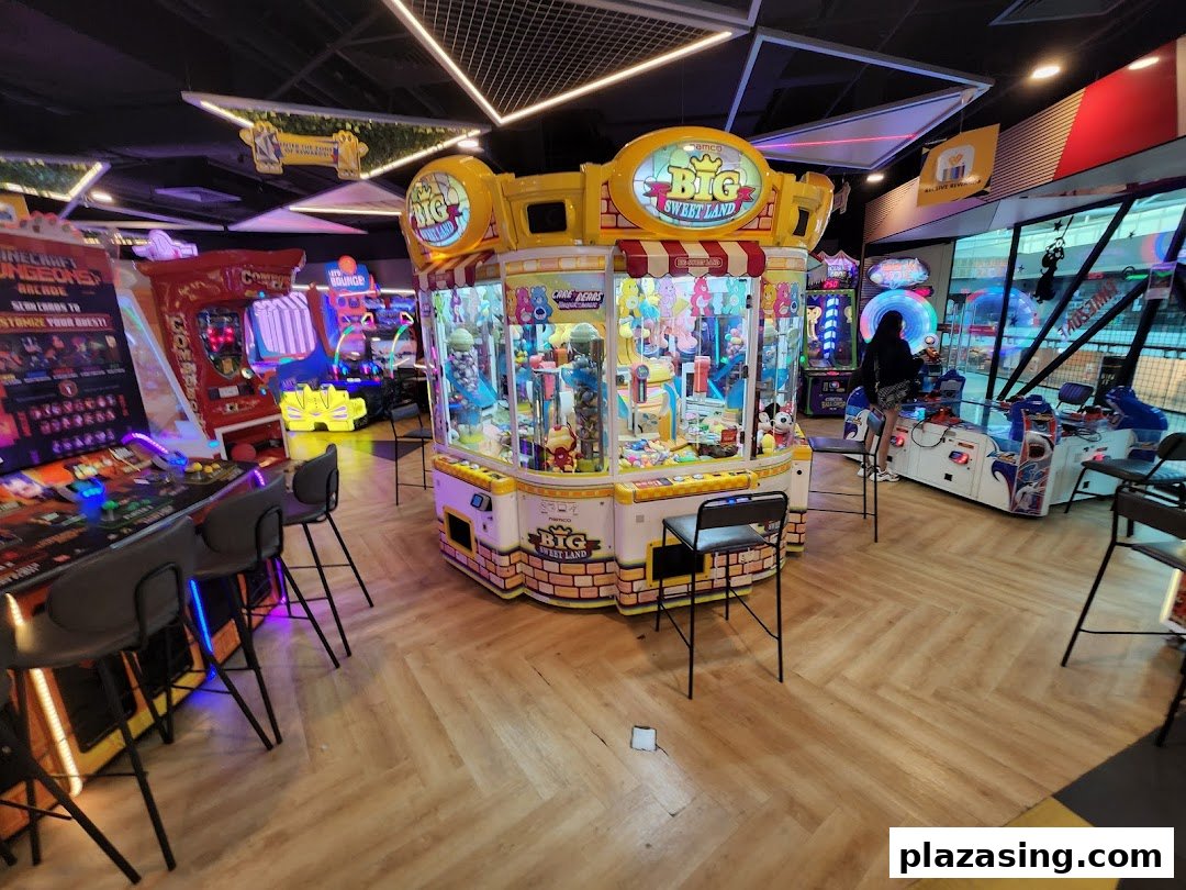 An arcade interior featuring various game machines, including a prominent 'Big Sweet Land' claw machine.