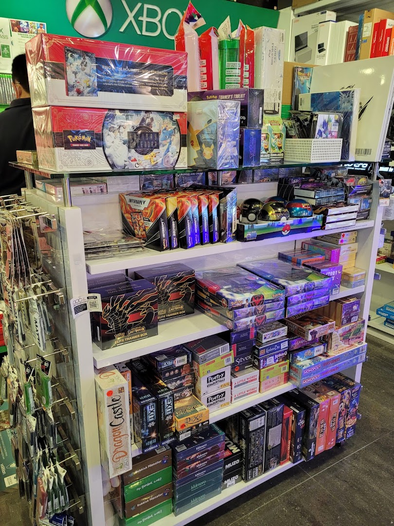 A vibrant retail display shelf showcasing a wide array of board games, card games, and collectibles.