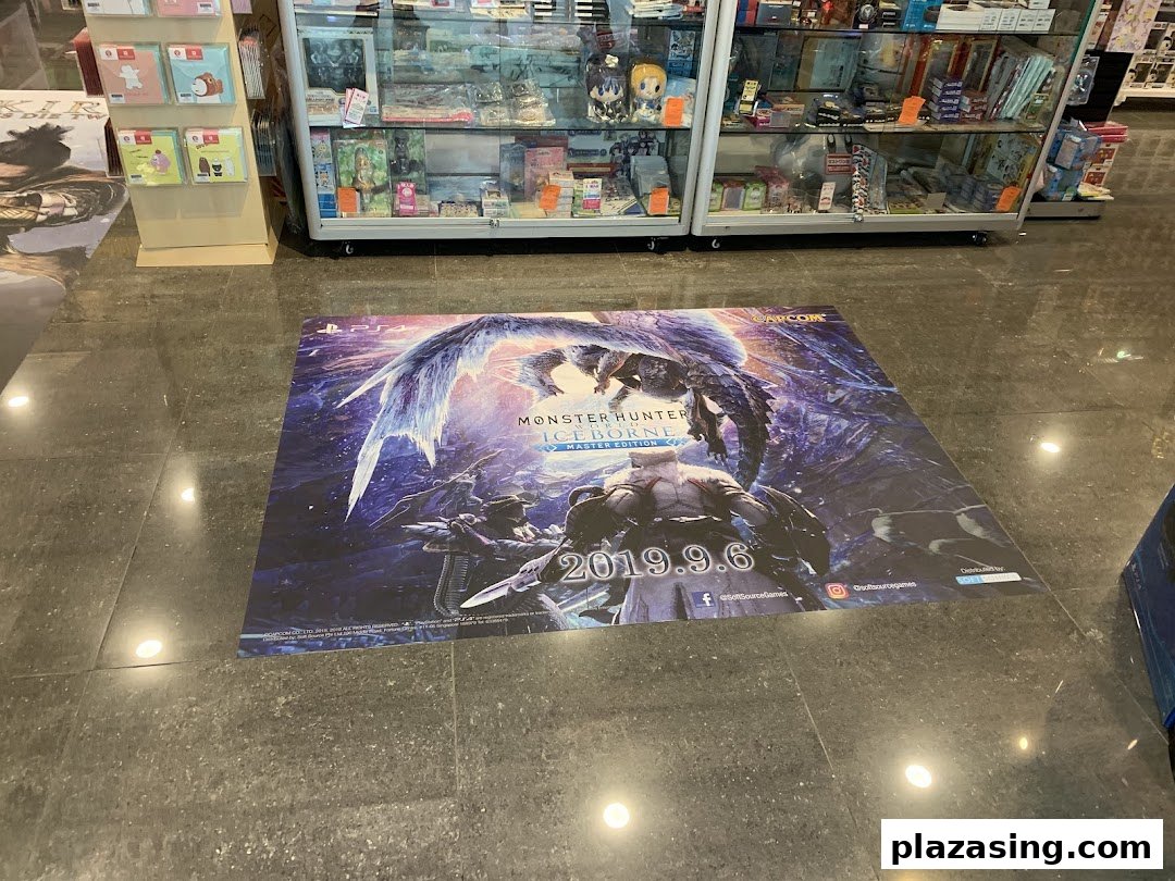 A large Monster Hunter Iceborne floor decal inside TOG - Toy Or Game Plaza Singapura, with display cases in the background.
