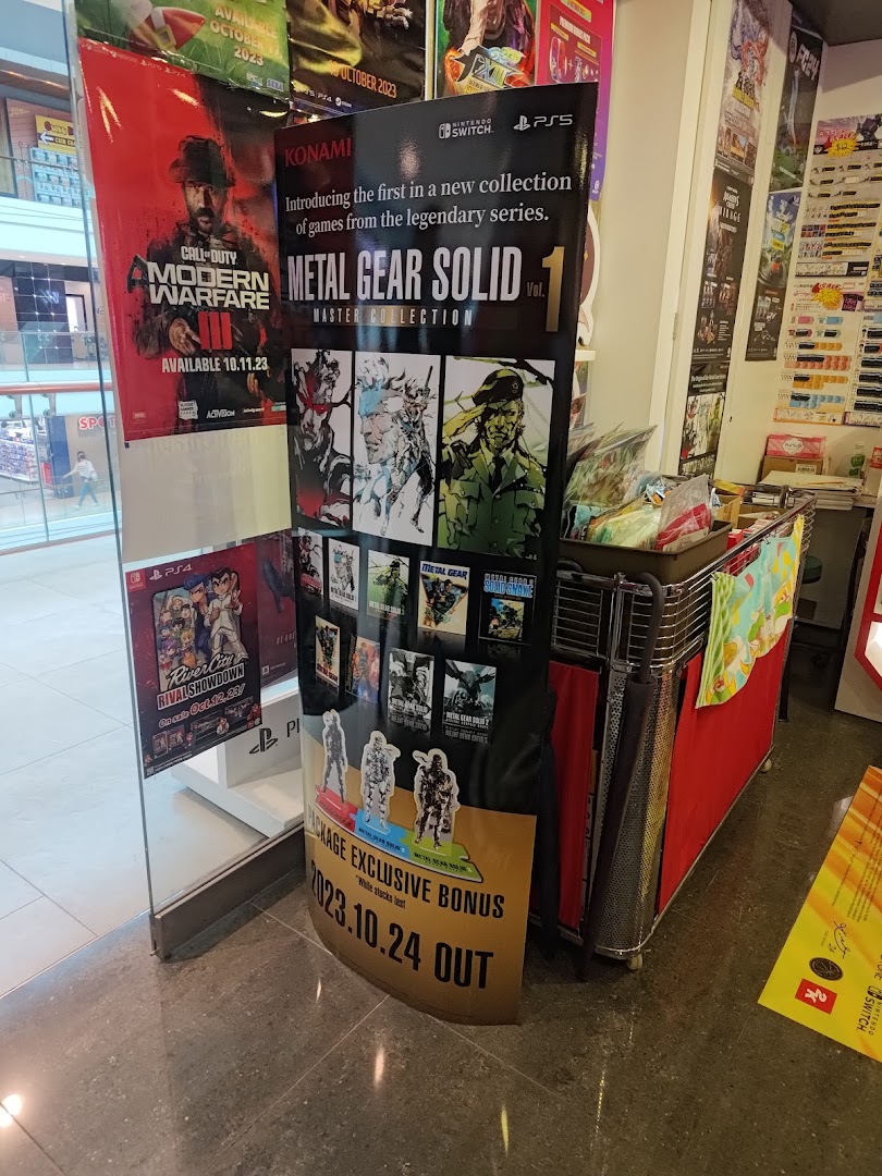 Promotional displays for new video game releases like Metal Gear Solid and Call of Duty inside a game store.