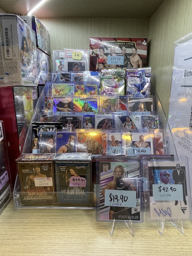 A display shelf showcasing various wrestling and sports trading cards, collectible card games, and sealed boxes.