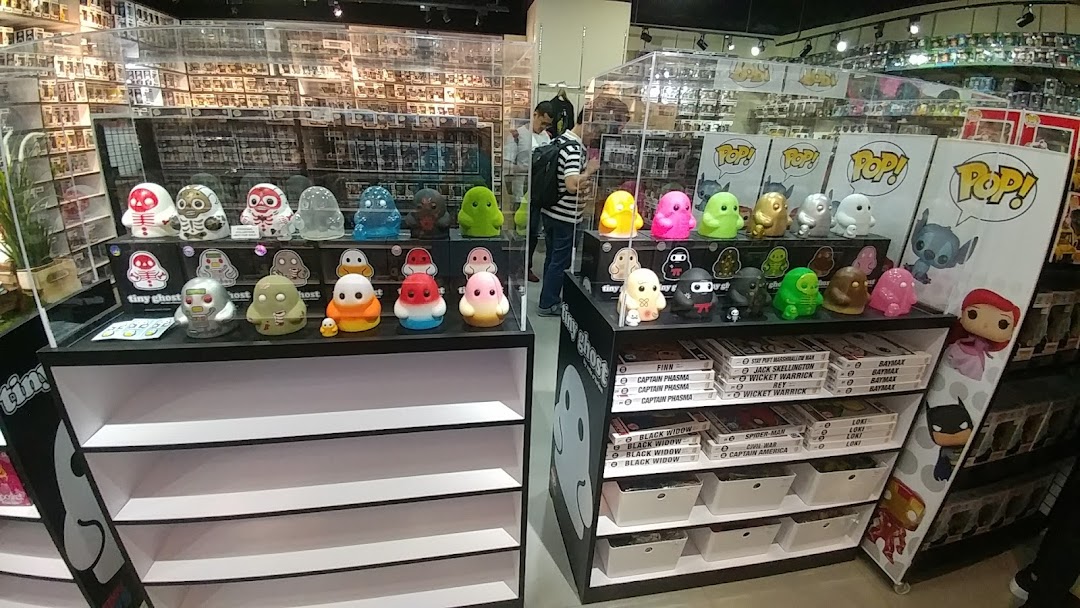 An interior view of Toy Outpost, showcasing colorful collectible figures like Tiny Ghost and Funko Pop! on display shelves.