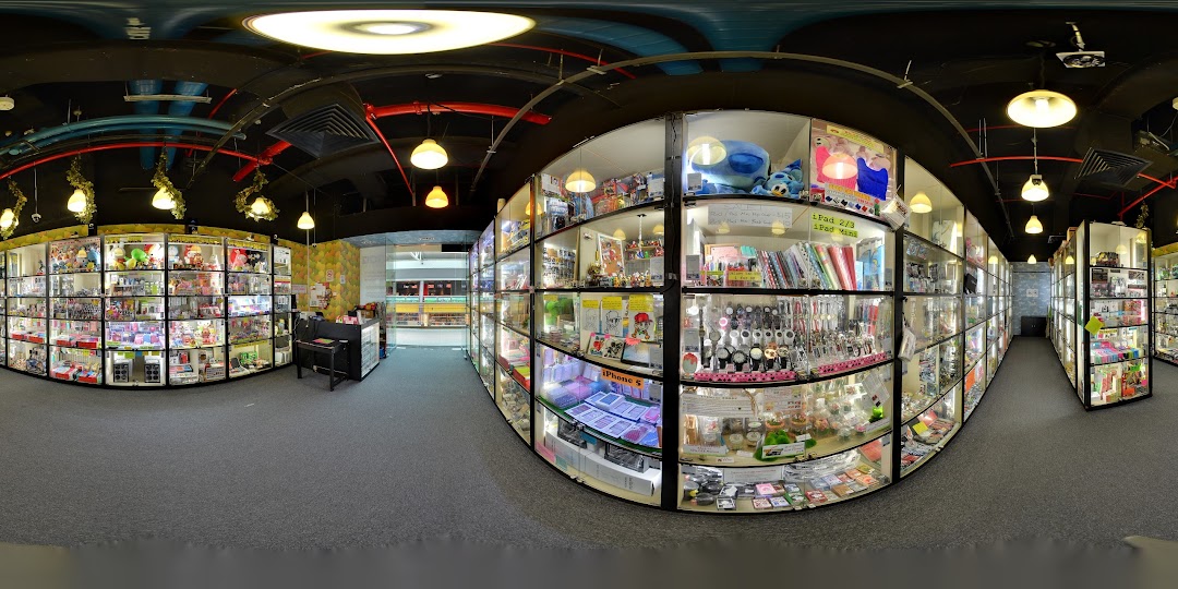 A panoramic view of Toy Outpost's interior, showcasing numerous glass display cases filled with diverse toys, collectibles, and novelty items.