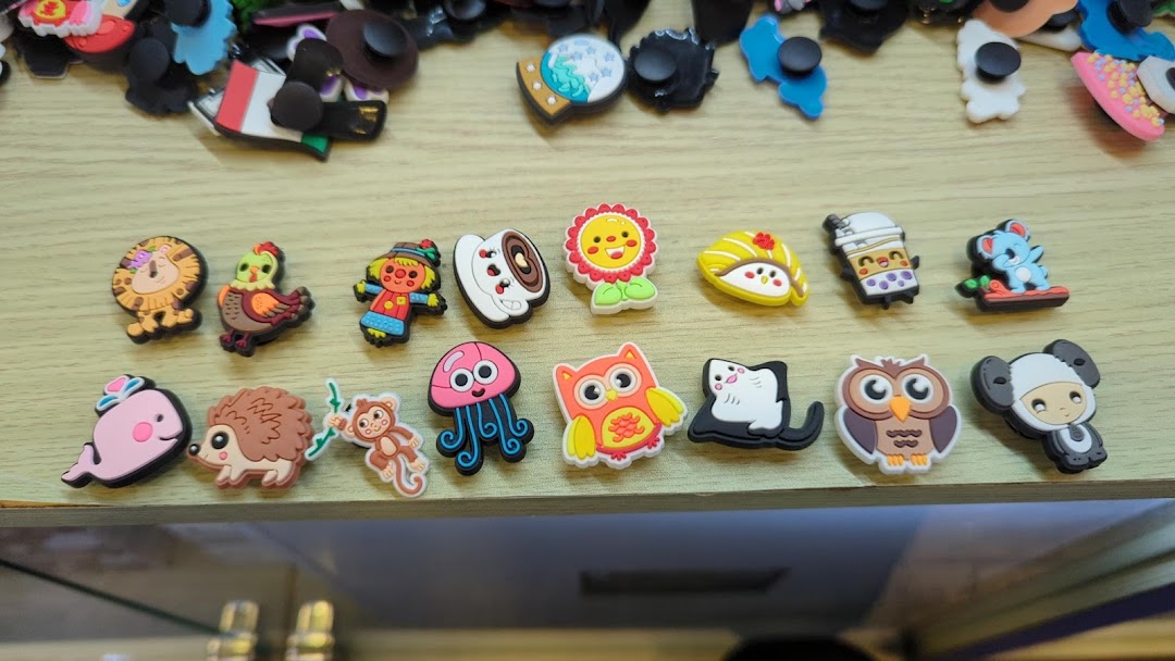 A close-up view of colorful, character-themed shoe charms displayed on a wooden surface.