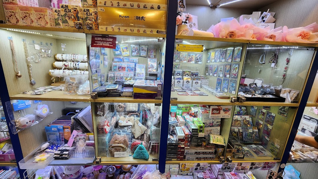 Brightly lit display cases showcasing a diverse collection of trading cards, jewelry, and various small gifts.