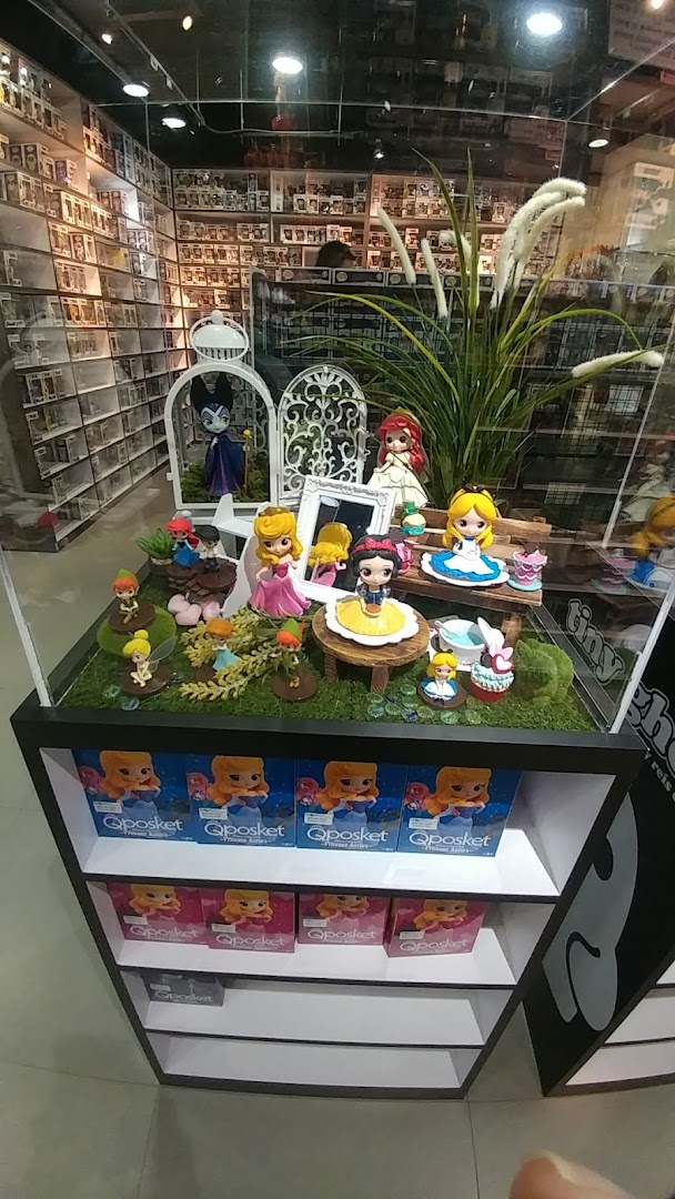 A vibrant display case featuring popular character figurines like Disney princesses and other collectibles, with shelves of boxed items.