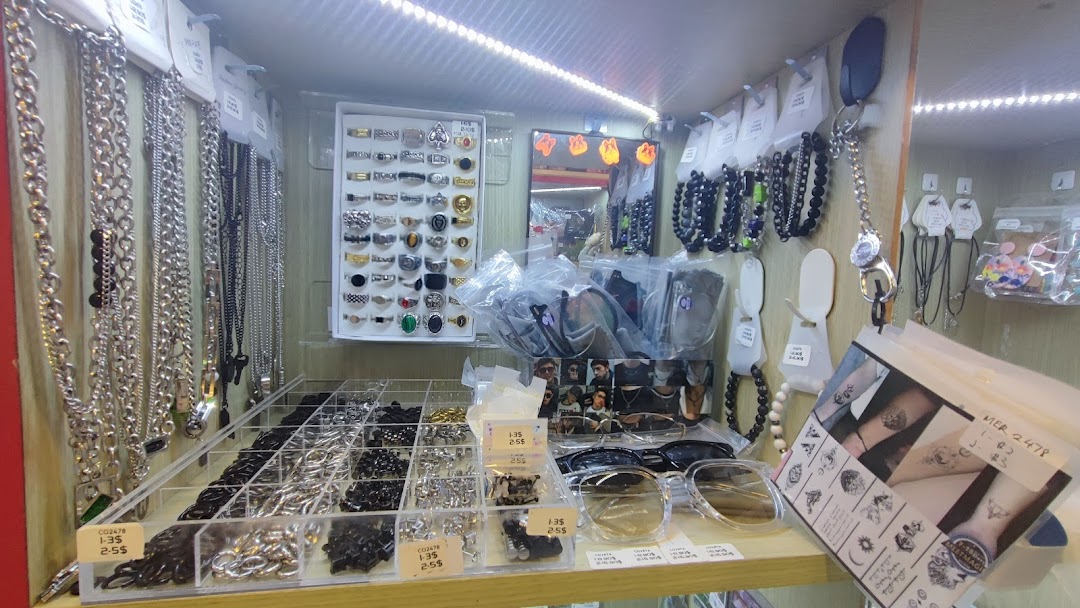 A retail display shelf showcasing various accessories like necklaces, rings, sunglasses, and temporary tattoos.