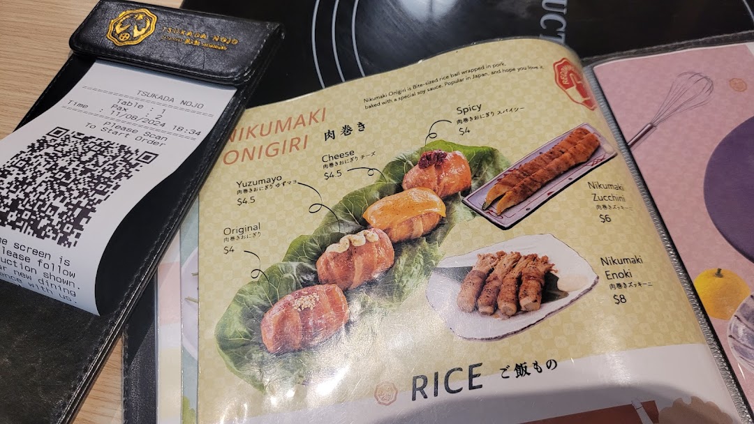 A menu page from Tsukada Nojo showcasing Nikumaki Onigiri and other Nikumaki items, with a QR code for ordering.