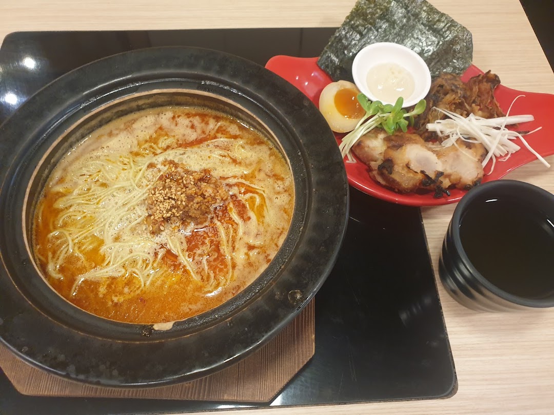 A delicious Japanese hotpot with noodles, accompanied by grilled chicken, egg, and seaweed.