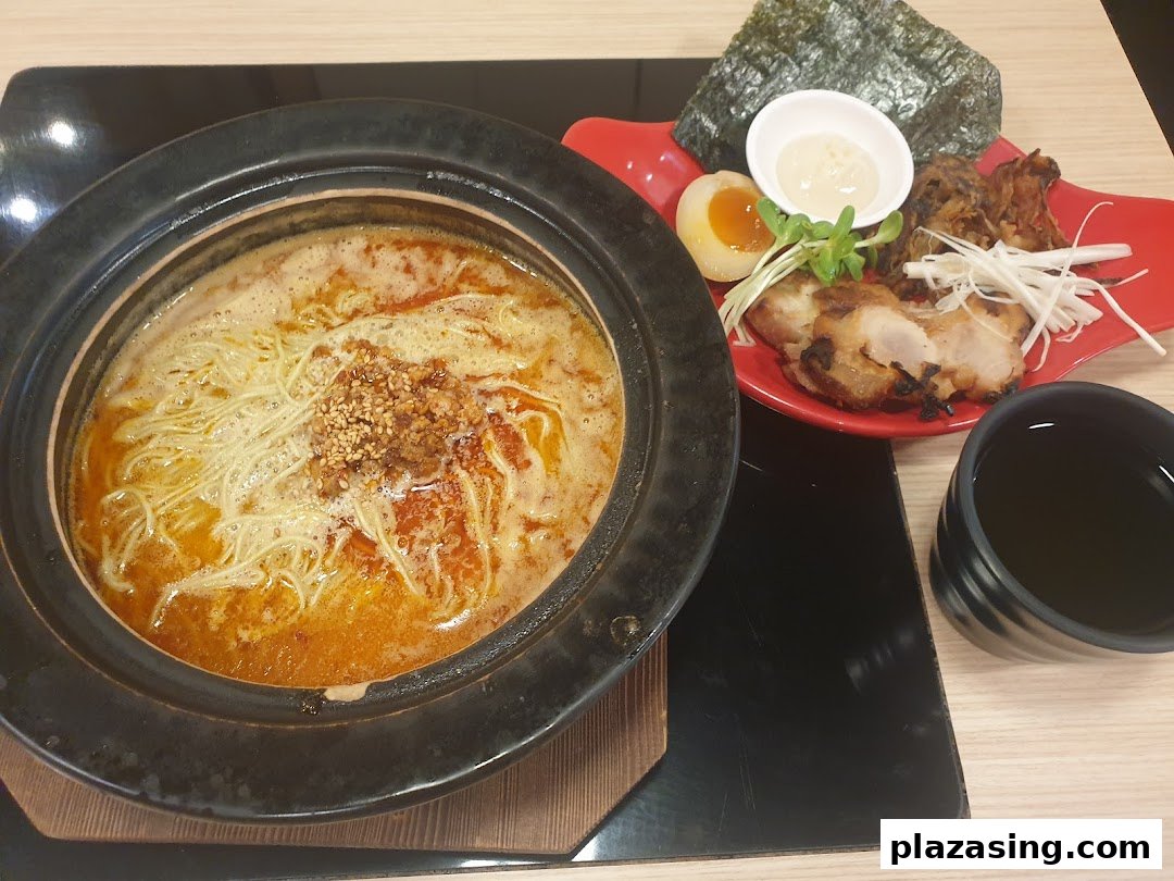 A delicious Japanese hotpot with noodles, accompanied by grilled chicken, egg, and seaweed.