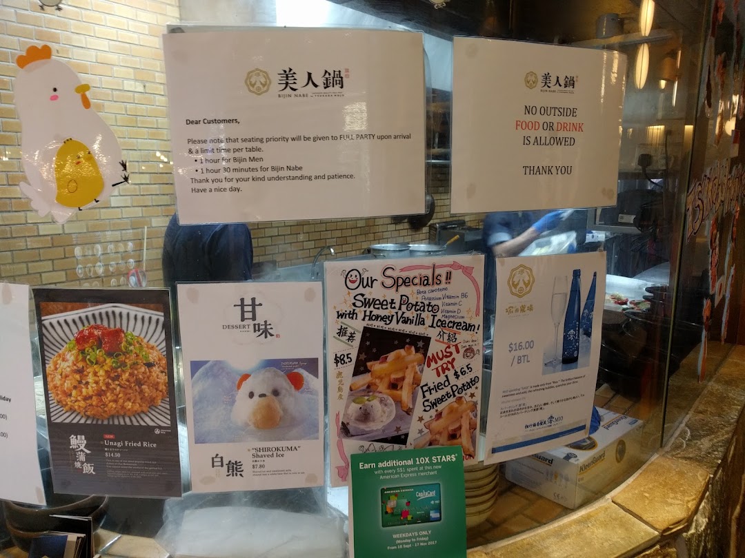 A display of menu items, specials, and customer notices at the entrance of a Japanese hotpot restaurant.