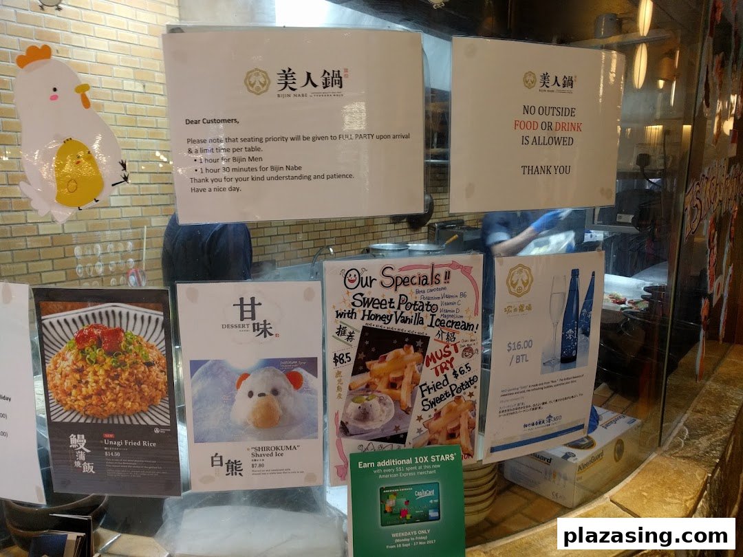 A display of menu items, specials, and customer notices at the entrance of a Japanese hotpot restaurant.