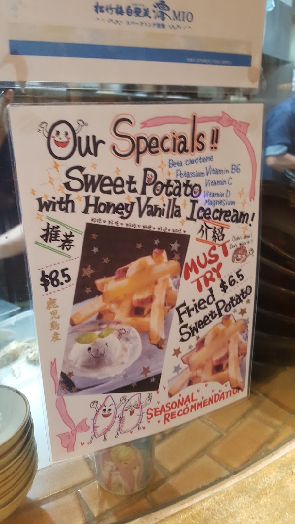 A vibrant promotional sign showcasing sweet potato specials with honey vanilla ice cream and fried sweet potato.