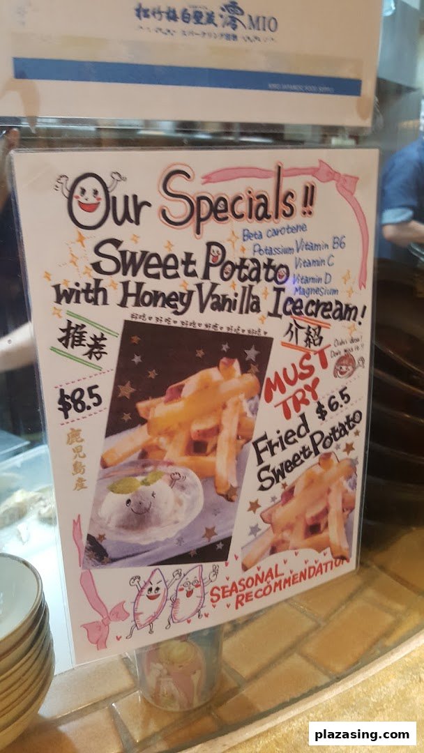A vibrant promotional sign showcasing sweet potato specials with honey vanilla ice cream and fried sweet potato.