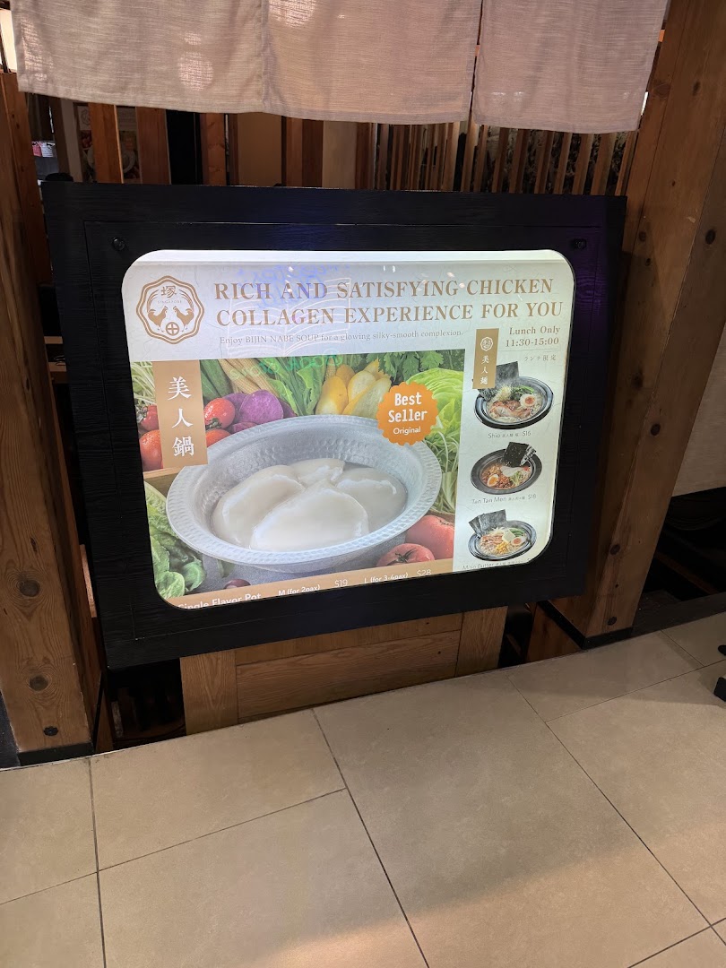 A lighted display board showcasing Tsukada Nojo's collagen hotpot and ramen dishes.
