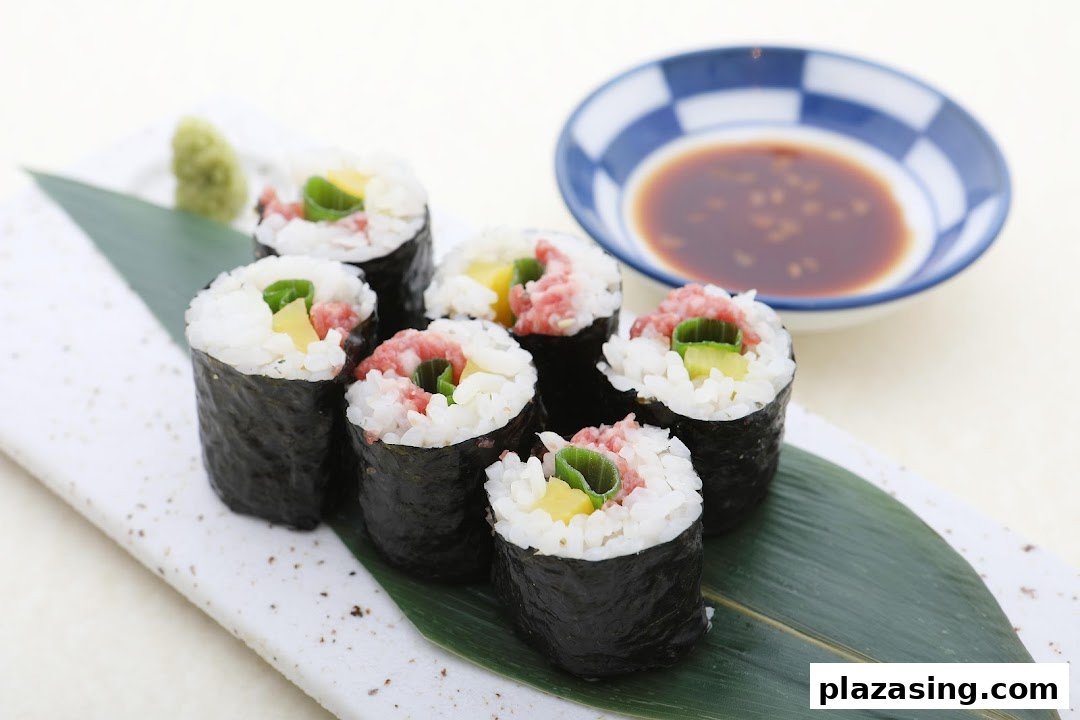 Close-up of six Japanese sushi rolls with rice, nori, and various fillings, served with wasabi and soy sauce.