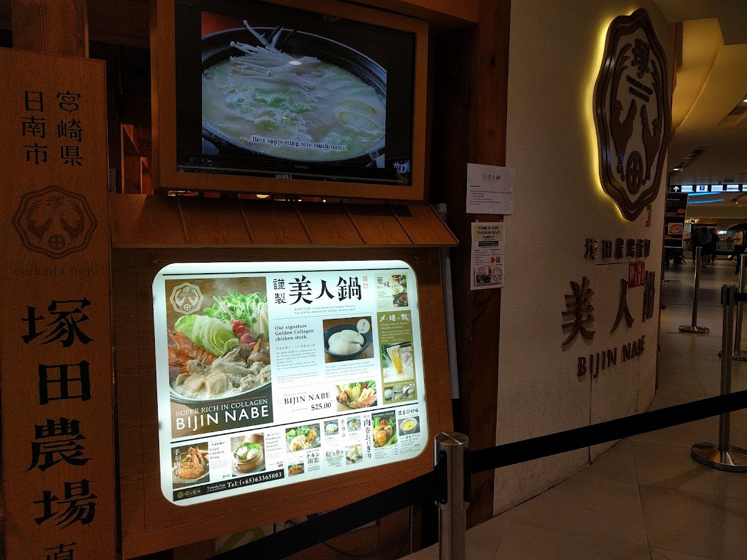 A vibrant shop entrance display featuring a menu board for collagen-rich hotpot and a video screen.