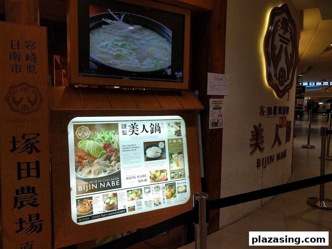 A vibrant shop entrance display featuring a menu board for collagen-rich hotpot and a video screen.