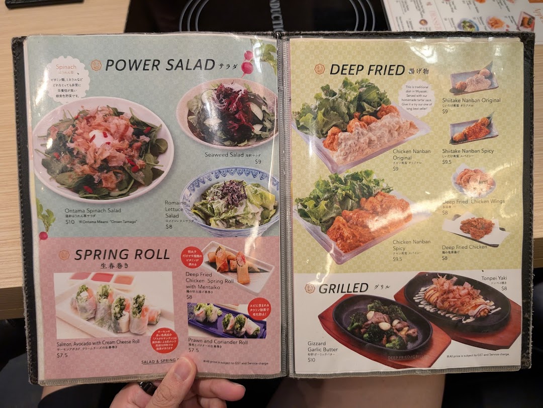 A detailed menu displaying various Japanese salads, deep-fried dishes, spring rolls, and grilled items.