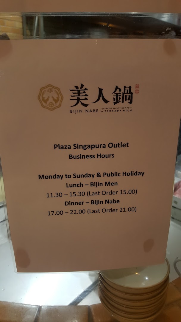 A sign displaying the business hours for Tsukada Nojo's Plaza Singapura outlet.