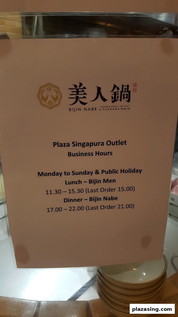 A sign displaying the business hours for Tsukada Nojo's Plaza Singapura outlet.
