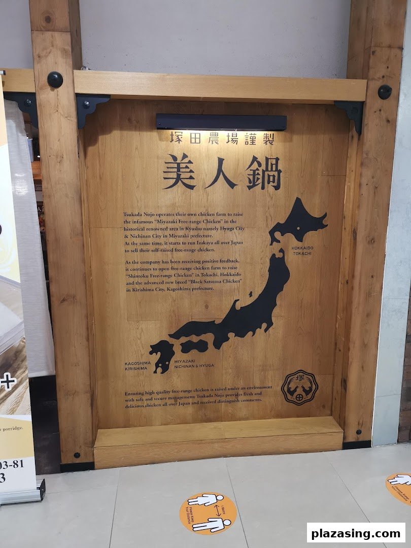 A wooden panel detailing Tsukada Nojo's premium free-range chicken sourcing with a map of Japan.