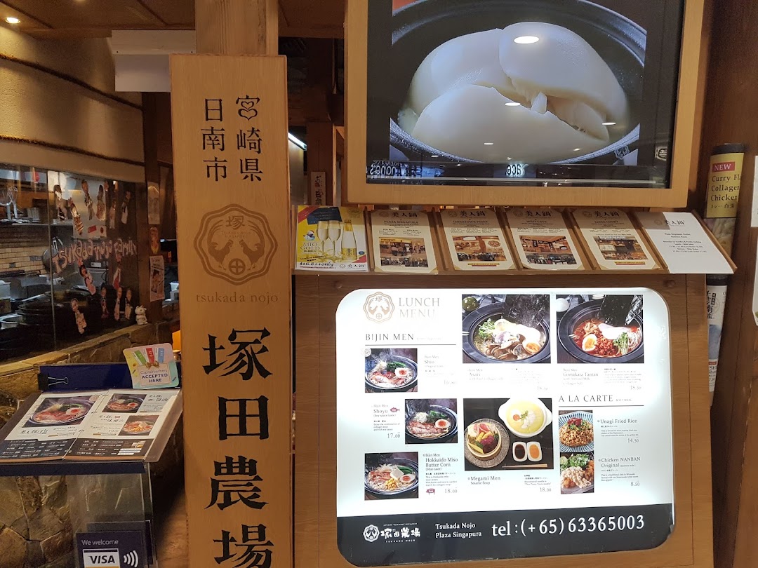 Entrance of Tsukada Nojo, featuring a large menu display, digital screen, and traditional Japanese signage.