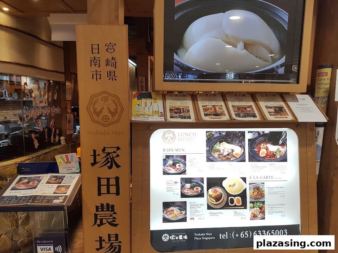 Entrance of Tsukada Nojo, featuring a large menu display, digital screen, and traditional Japanese signage.