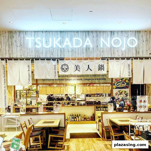 The illuminated entrance of Tsukada Nojo, a Japanese farm-to-table restaurant, showcasing its inviting dining area.